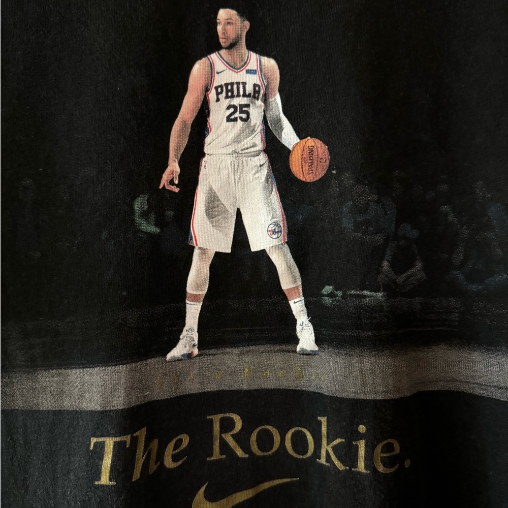 “The Nike Tee” in black. Size Men’s medium.  “The Rookie” graphics on the front.